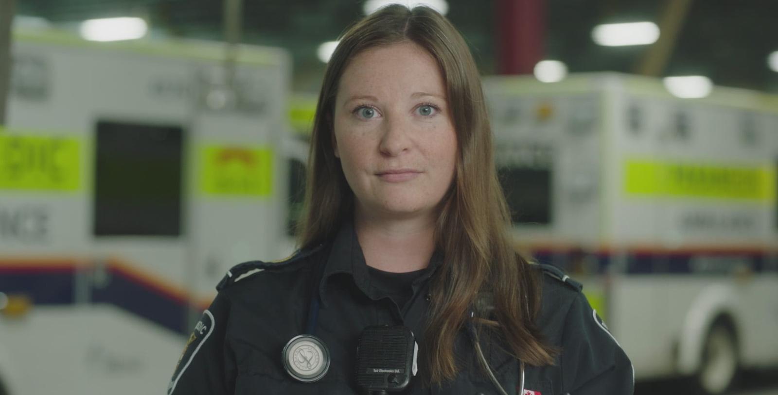 Paramedic standing in front of ambulances